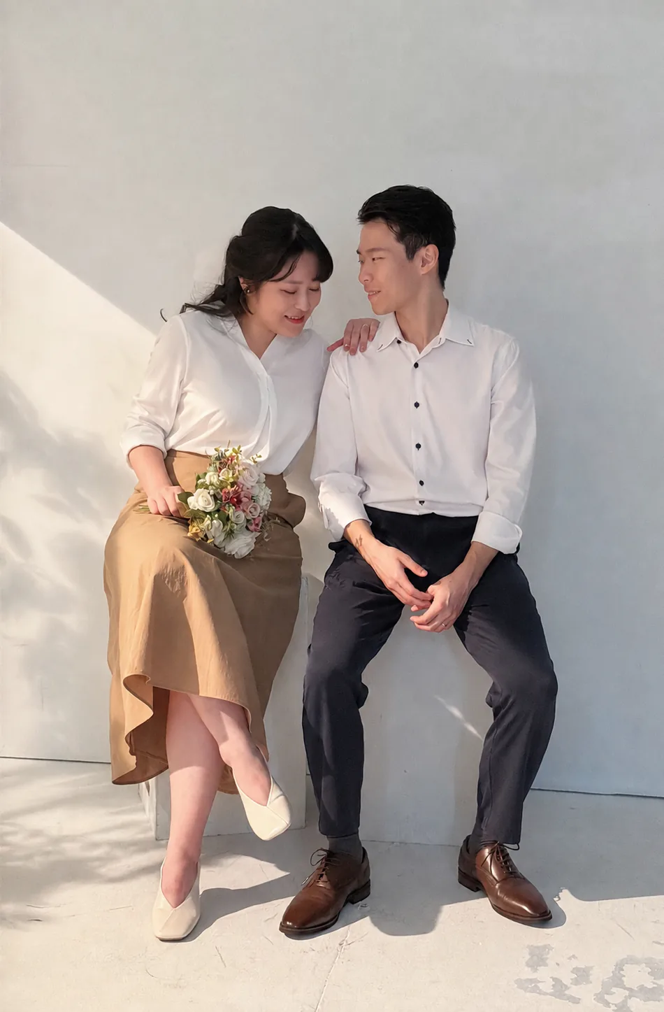 Harry 與 Cynthia 在陽光牆邊並肩而坐的合照