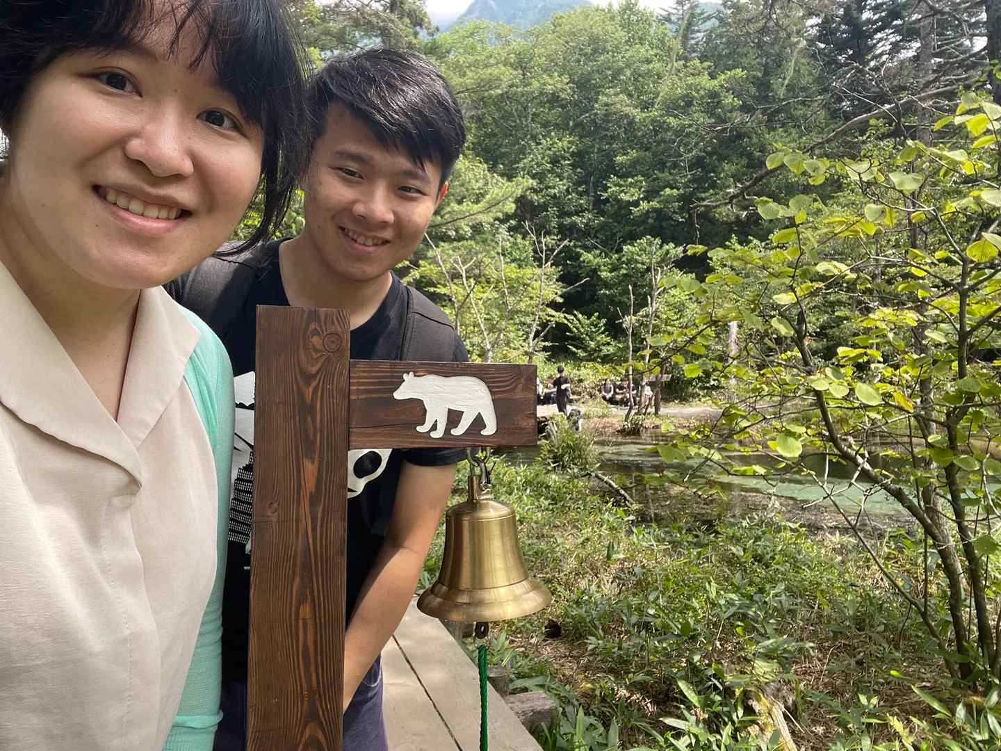 Harry 與 Cynthia 在山林裡的熊鈴旁合照